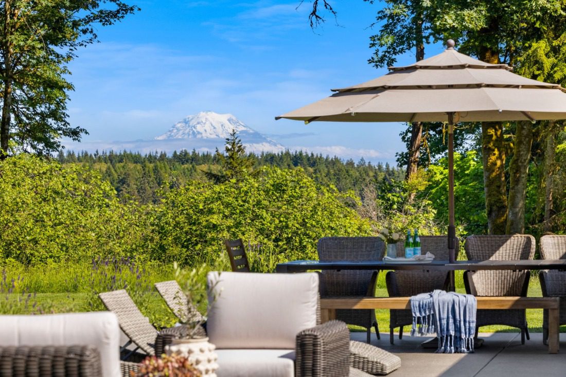 backyard patio of modern farmhouse in gig harbor with Mr Rainer in the background, surrounded by lush trees